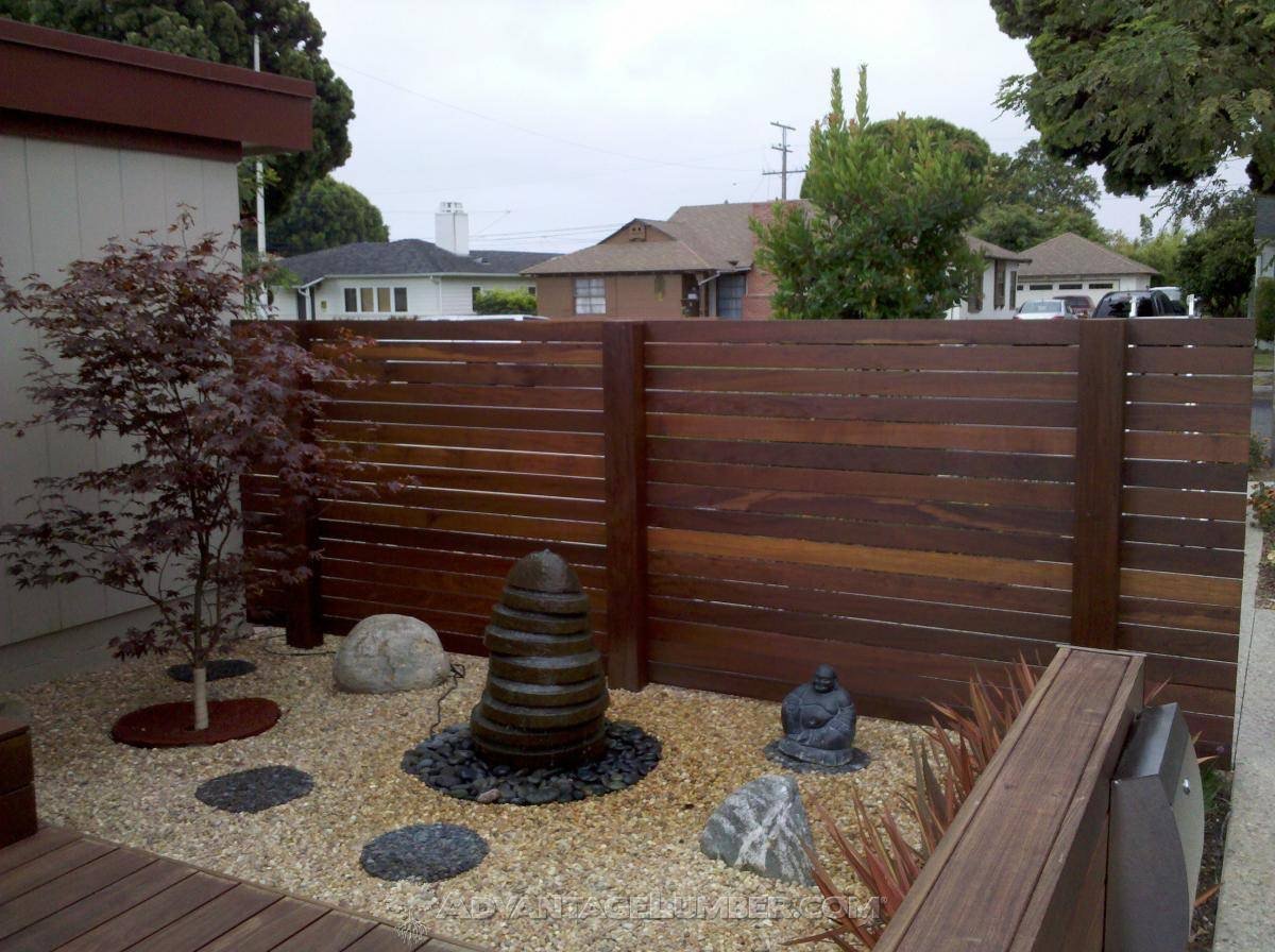 Wooden privacy fence in a landscaped yard